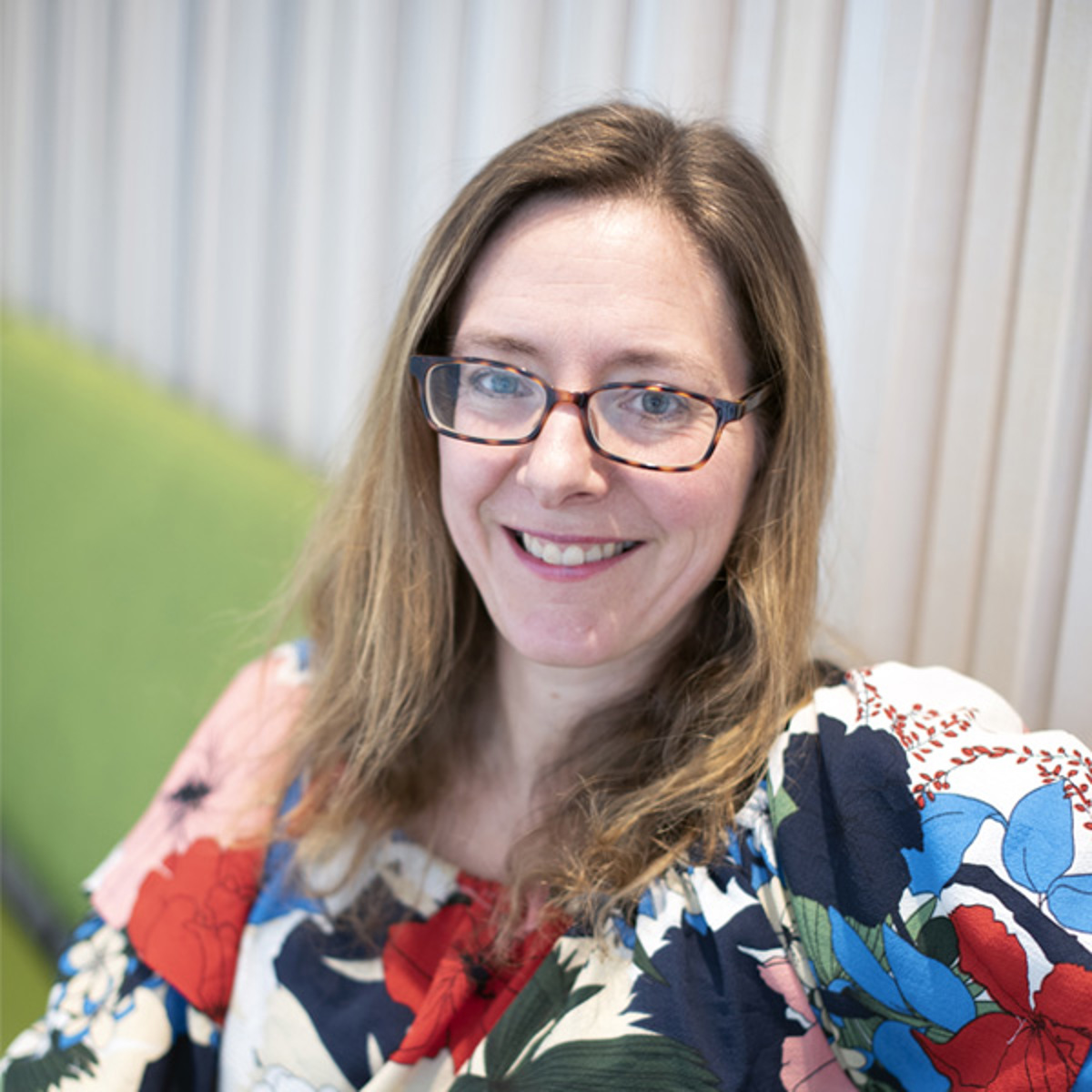 Porträttbild av Andrea Eriksson, professor vid avdelningen för ergonomi på KTH, i färgglad blus och glatt leende