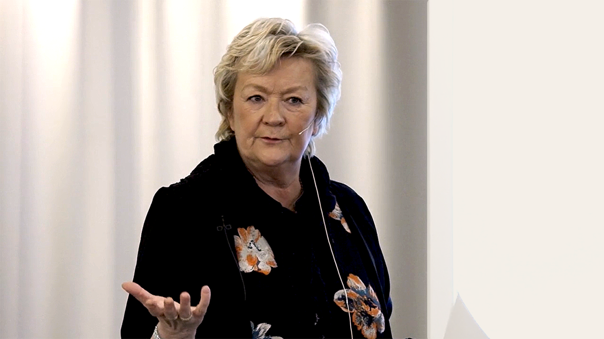 Person med mikrofonheadset framför en vit gardin.