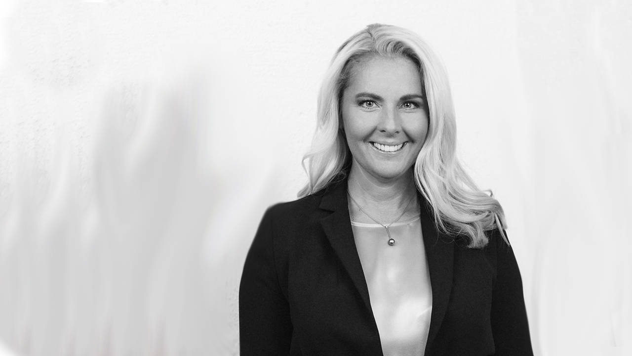 Person iförd mörk kavaj och ljus blus.