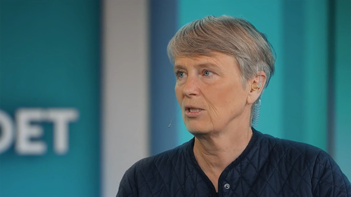 Person iförd svart vårjacka stående i studiomiljö