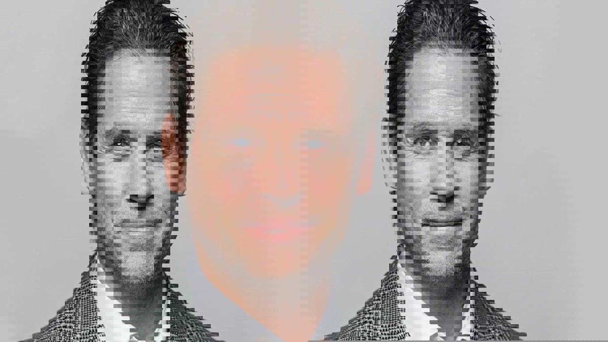 Person iförd rutig kavaj och vit skjorta.