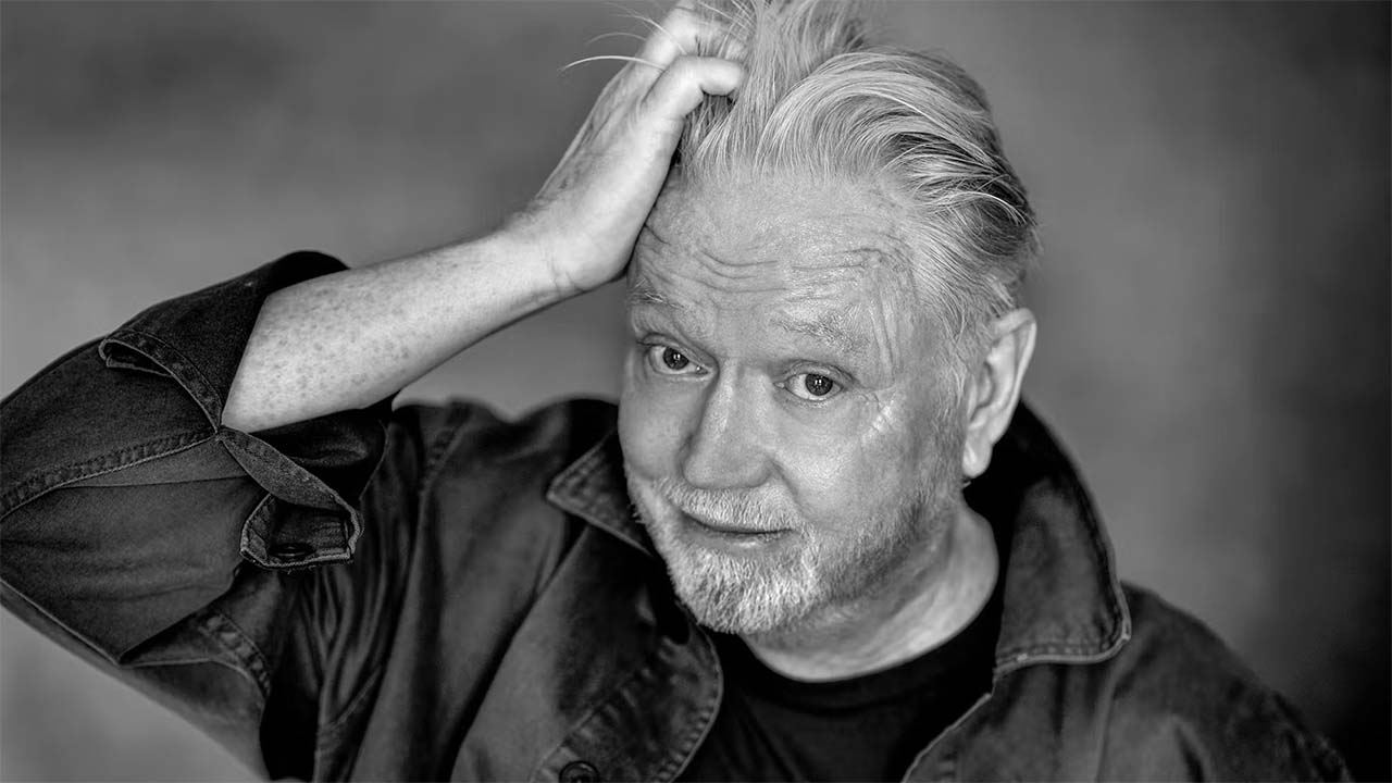 Person iförd jeansskjorta med blå t-shirt under.