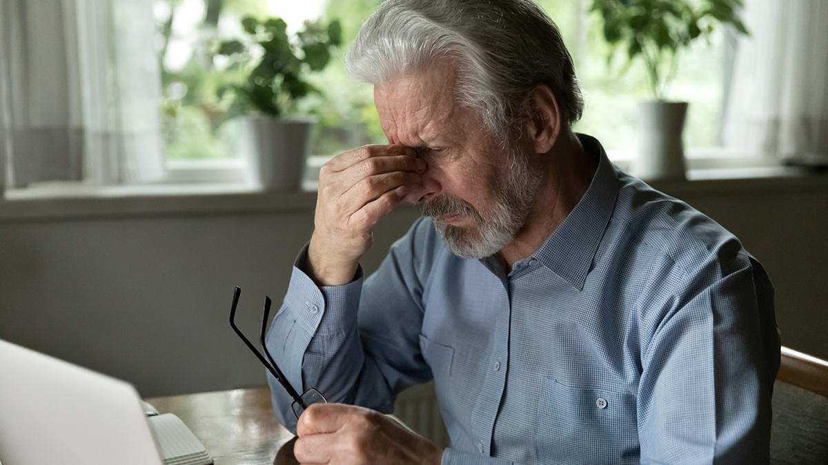 Bekymrad man framför en datorskärm.