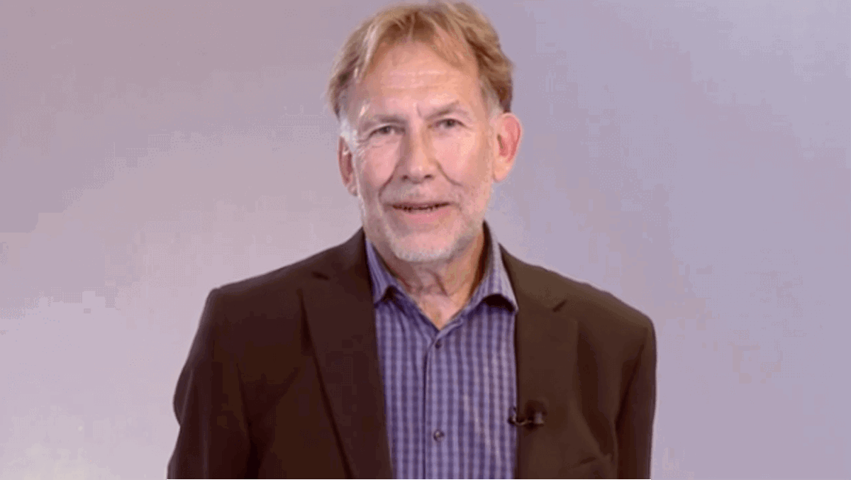 Bild på person med kavaj och rutig skjorta.