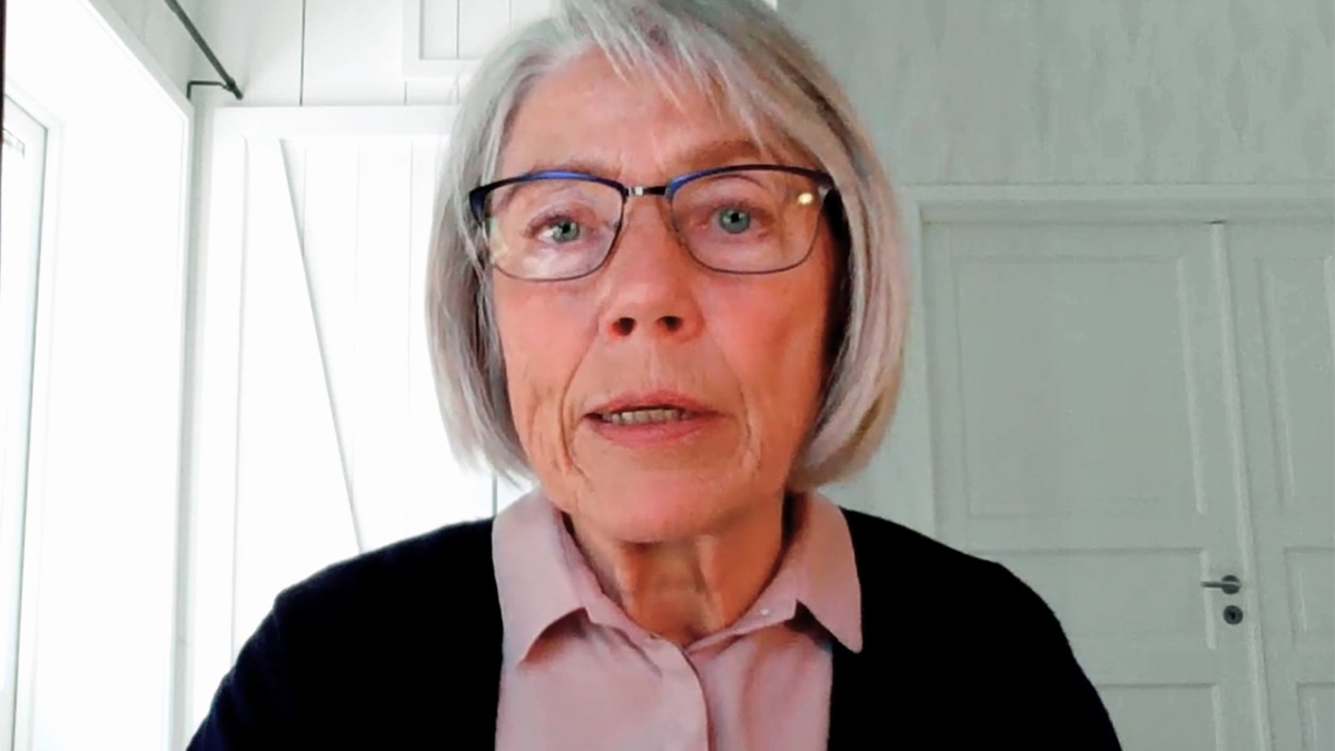 Huvudbild av person i hemmamiljö (vita väggar och dörrar) som blickar in i datorkameran.