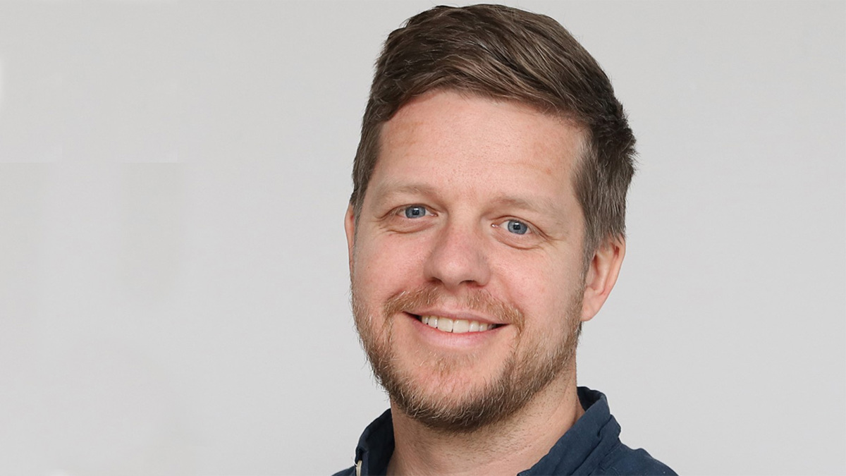 Person med mörkt hår och skägg.