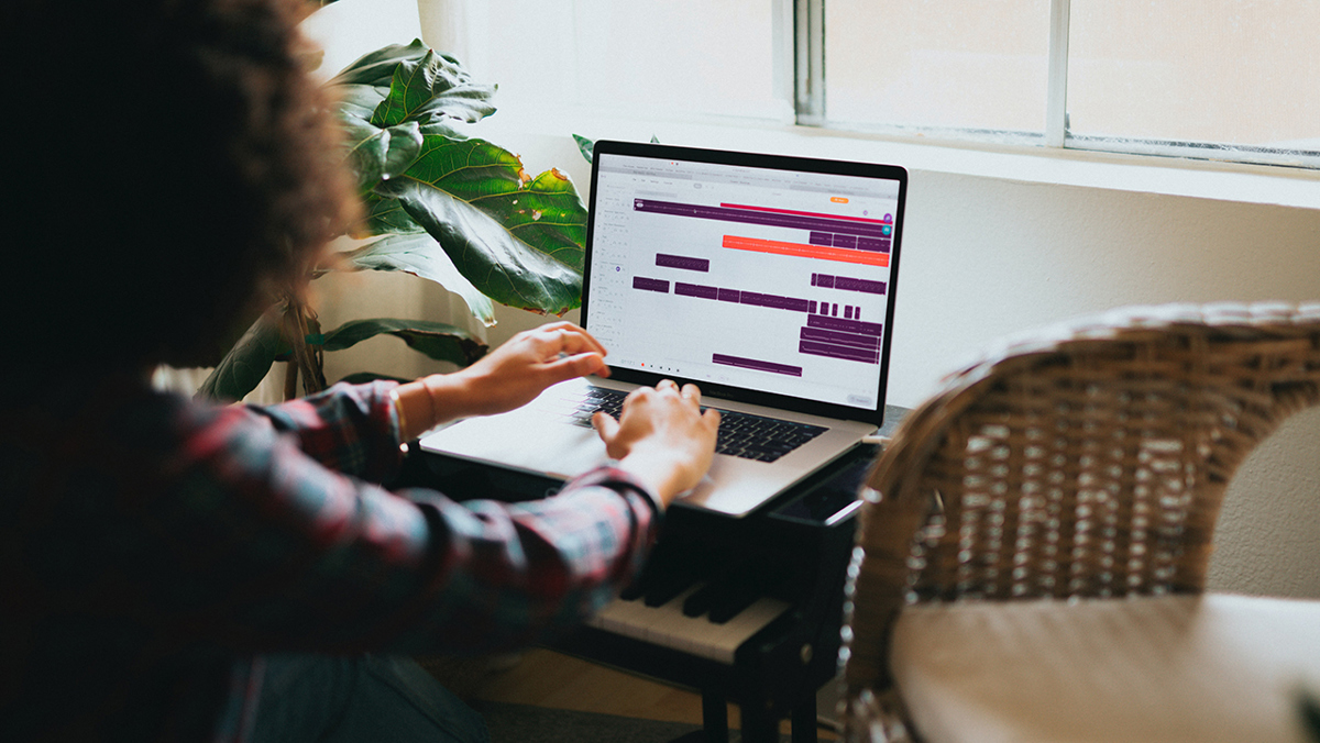 Person framför dator i hemmamiljö.