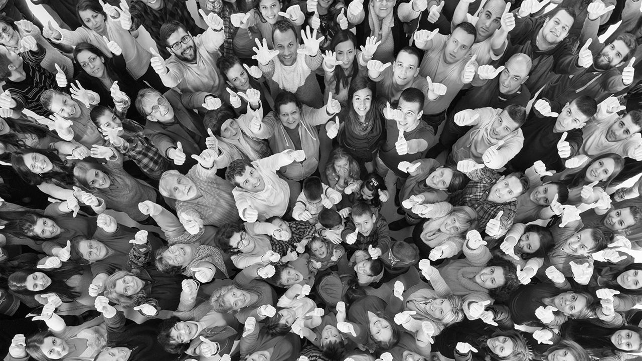 En stor mängd människor (olika åldrar och ursprung) står tätt tillsammans som i en snirklig spiral.