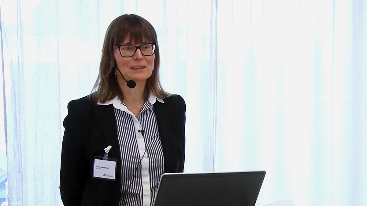 Person med mikrofonheadset framför vitt draperi.