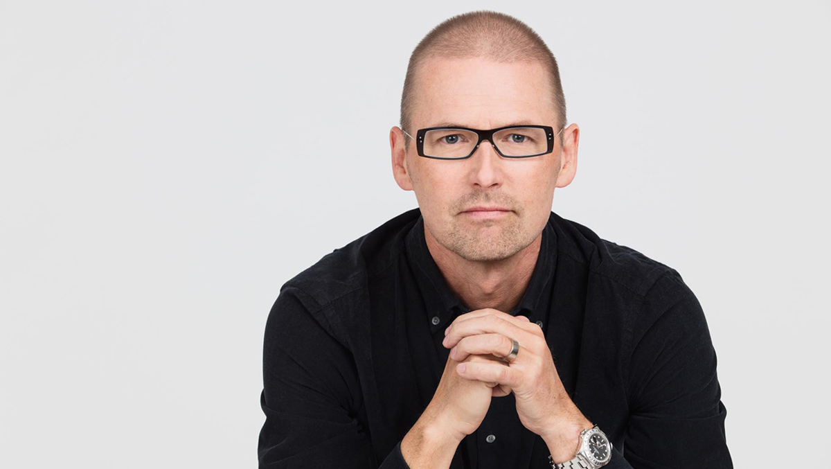 Bild på person iförd svart skjorta och svarta glasögon.