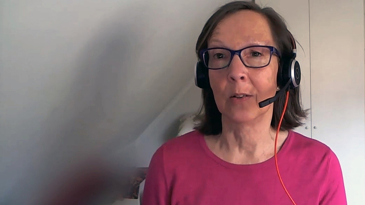 Person med headset som håller föredrag framför skärmen