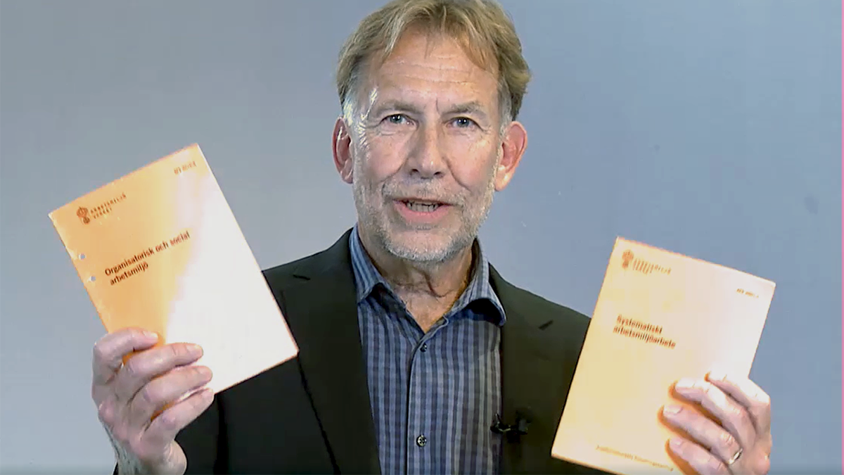 Person som visar upp två föreskrifter från Arbetsmiljöverket.