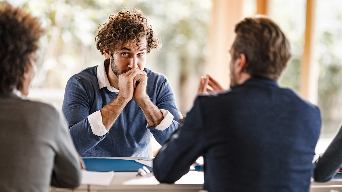 Mötessituation där en av personerna ser nervös ut.