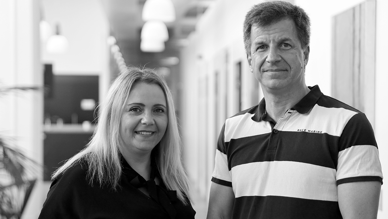 Två personer stående i en korridor.