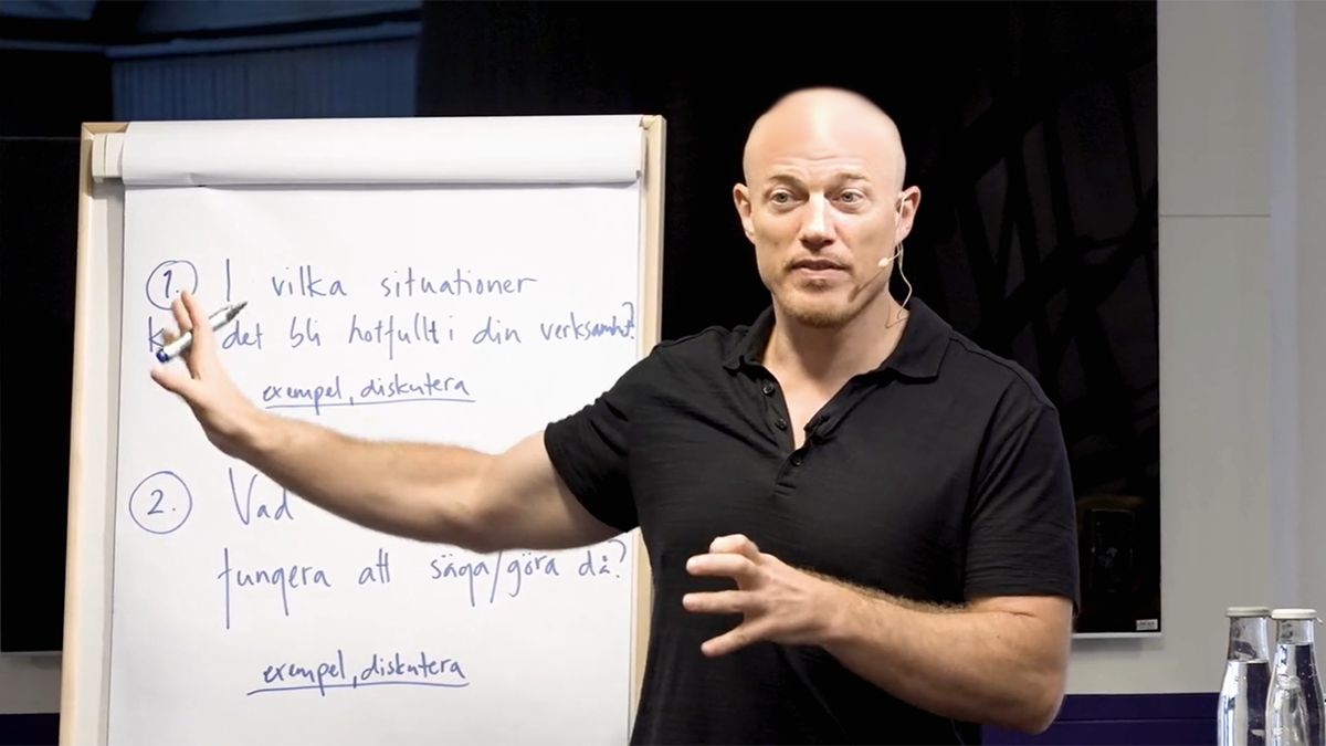 Person med mikrofonhedadset framför blädderblock.