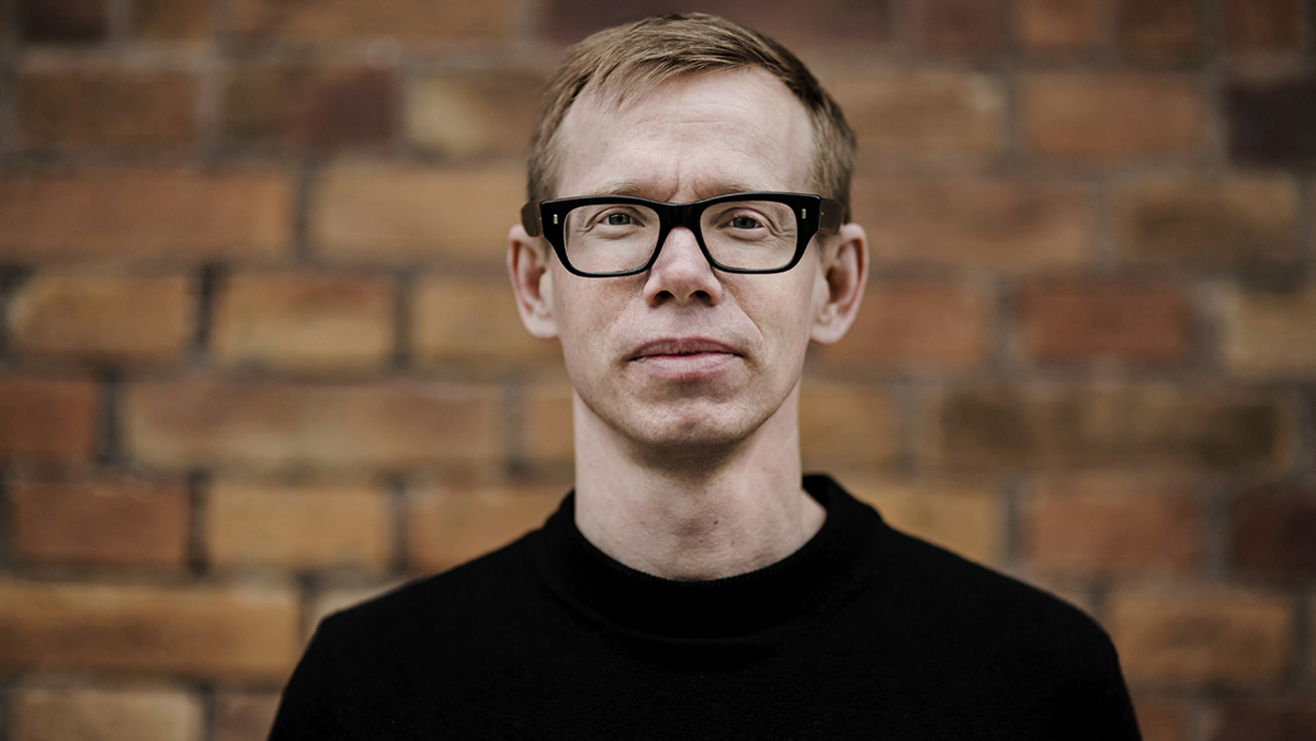 Person (Tobias Degsell) som står framför en gul tegelvägg